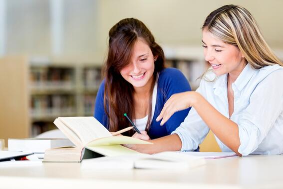 Happy female students at the library studying-1